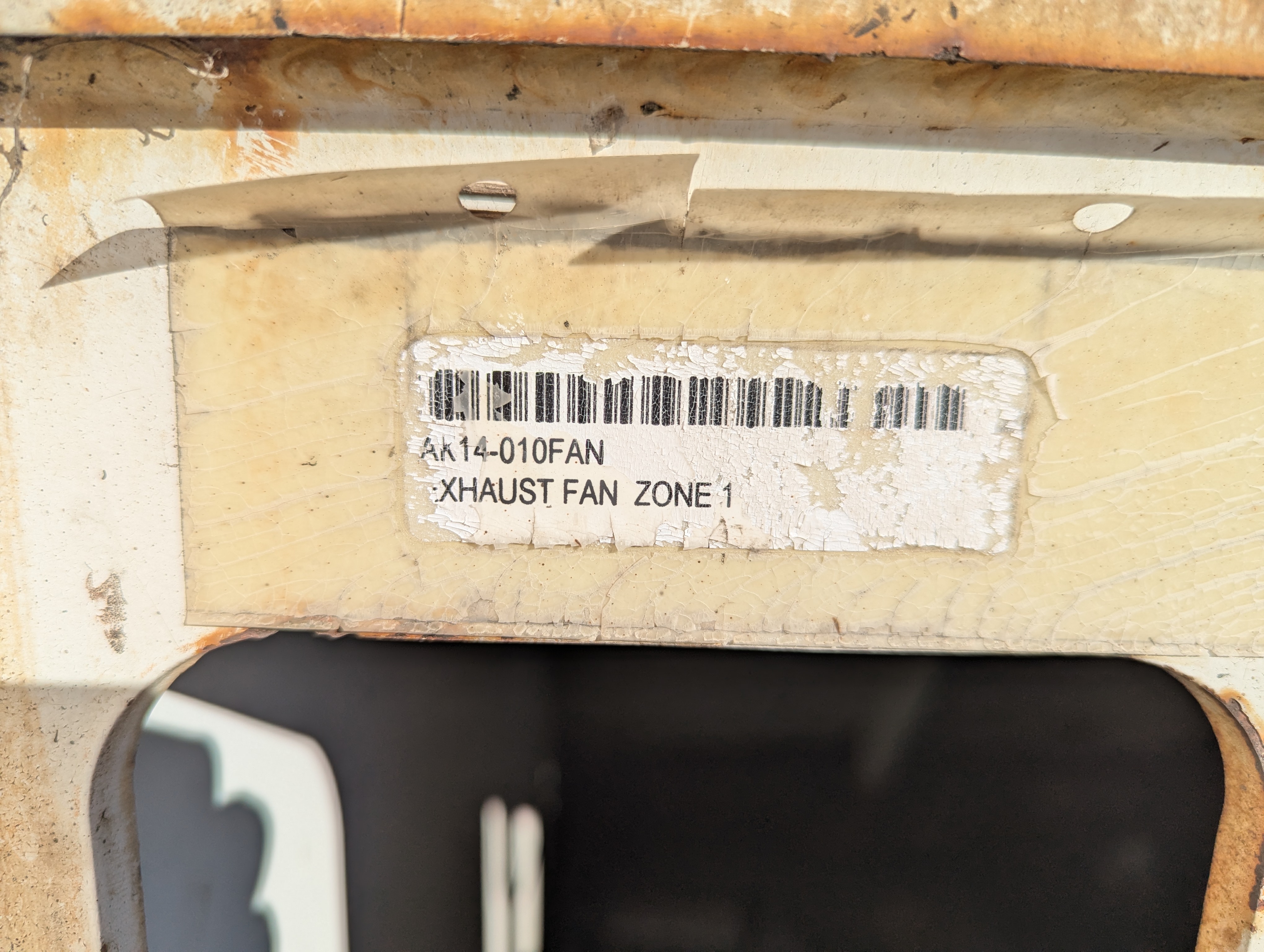 Cracked and peeling barcode label on industrial equipment